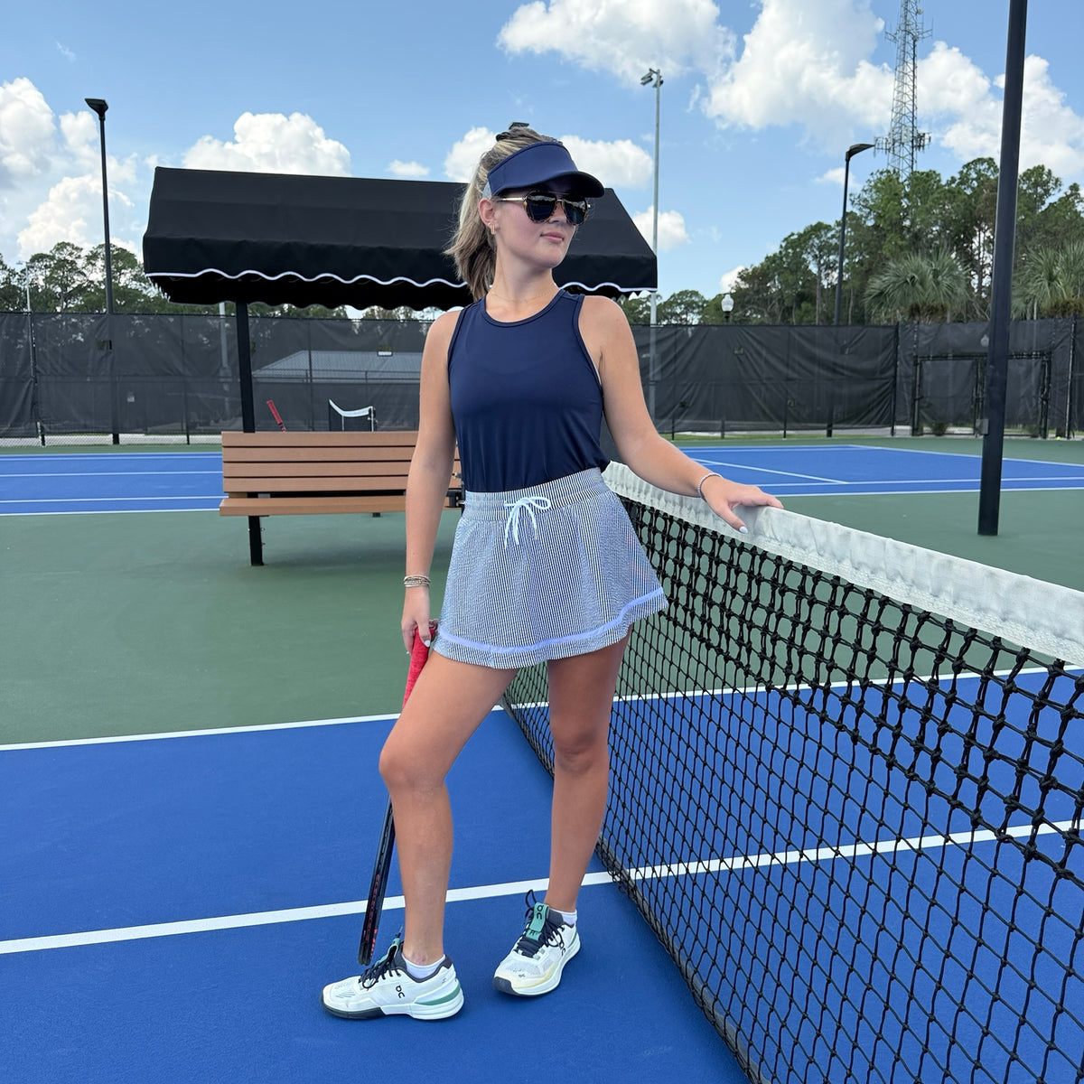 Lucky in Love navy seersucker skirt styled on tennis court